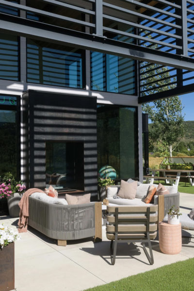 Seamless indoor/outdoor areas open to the front lawn while back steps lead into the meadow and a private firepit area. Landscaping features native meadow plantings and trees so the home feels grounded in the local environment.